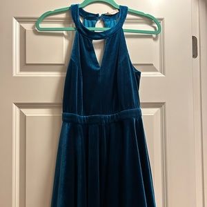 Teal velvet winter dress with v-neck and open back detail.